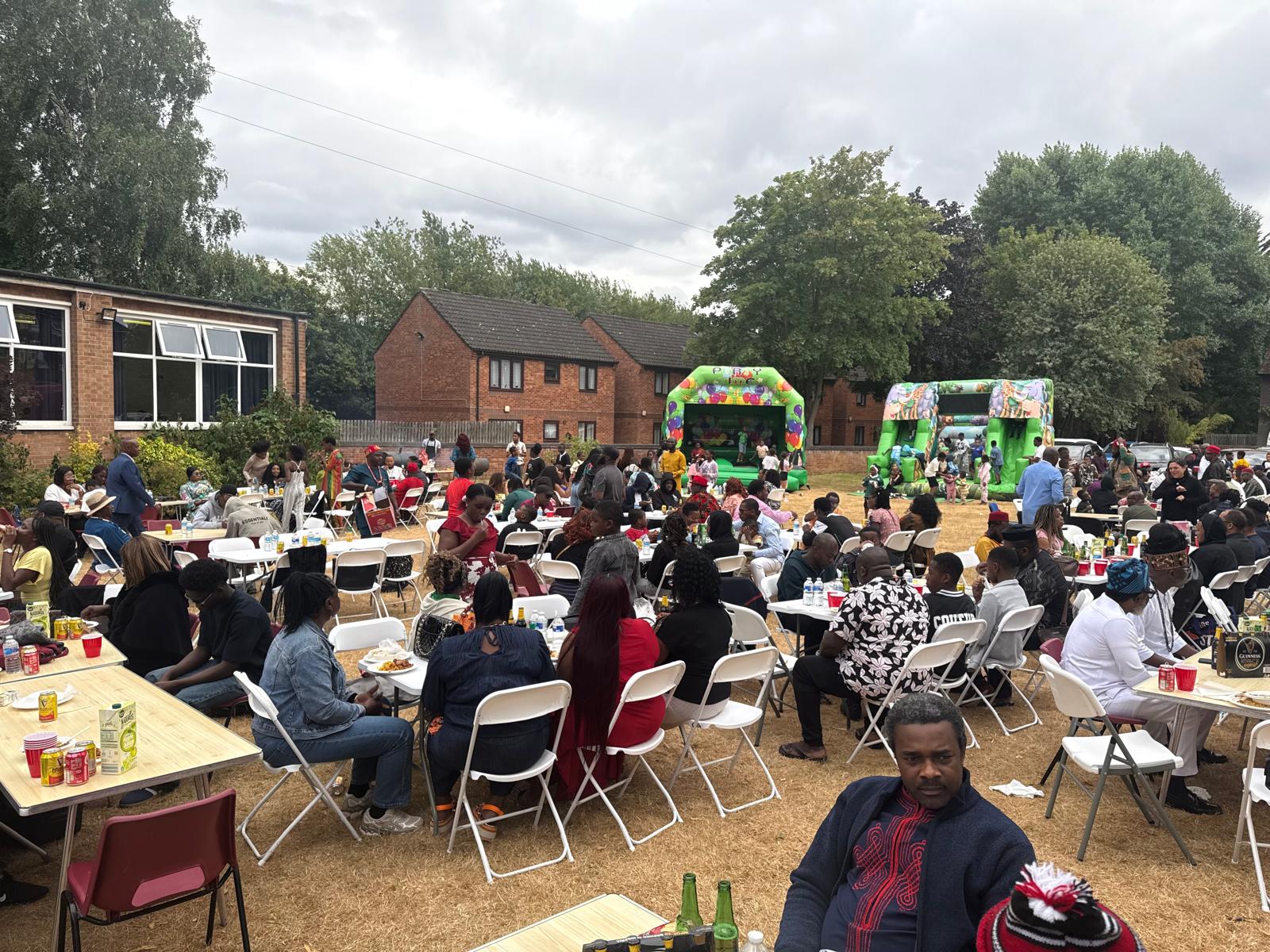Wide view of the AUF family fun day with bouncy castles and guests