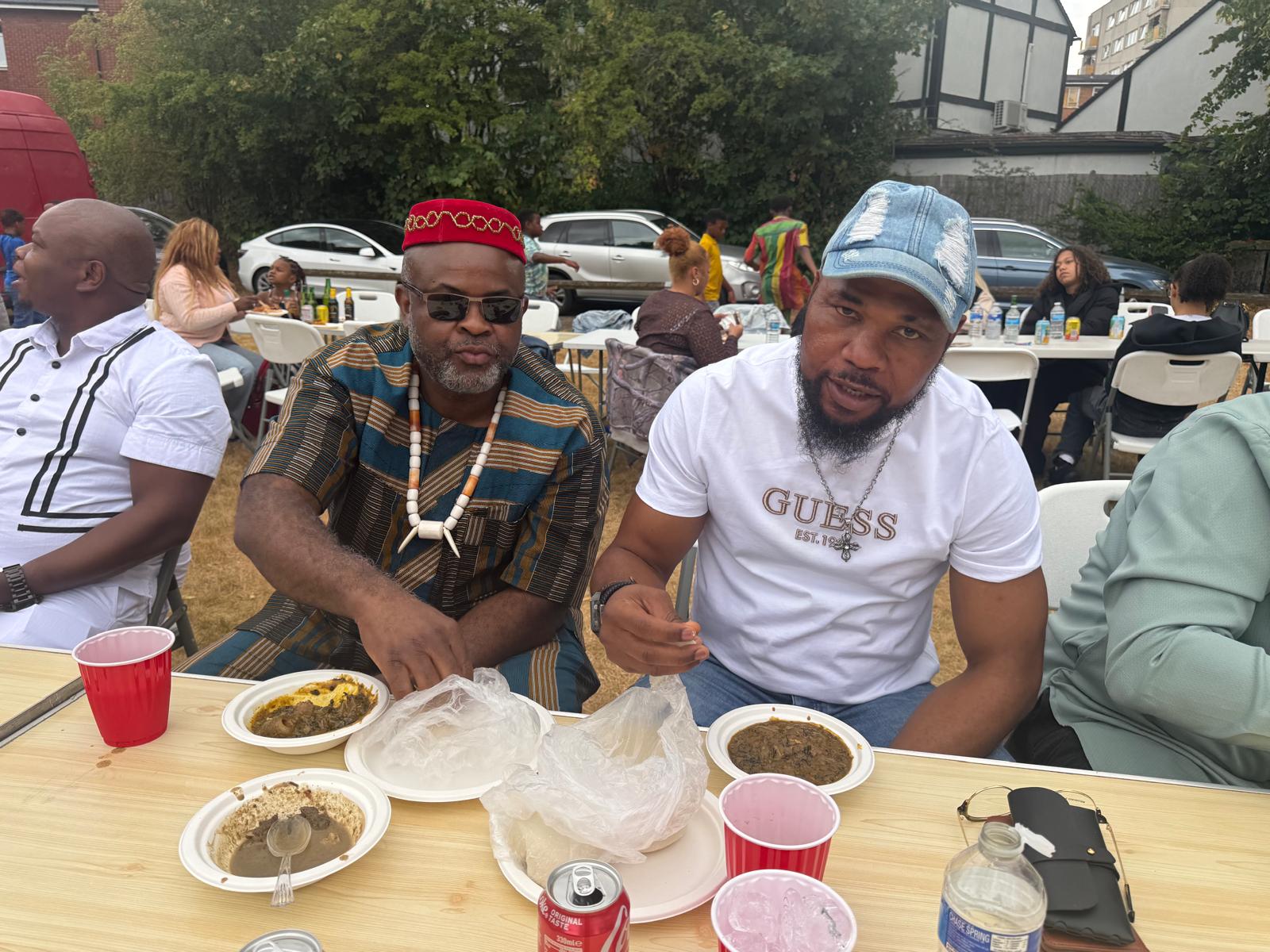 Two members enjoying Nigerian dishes at the AUF picnic
