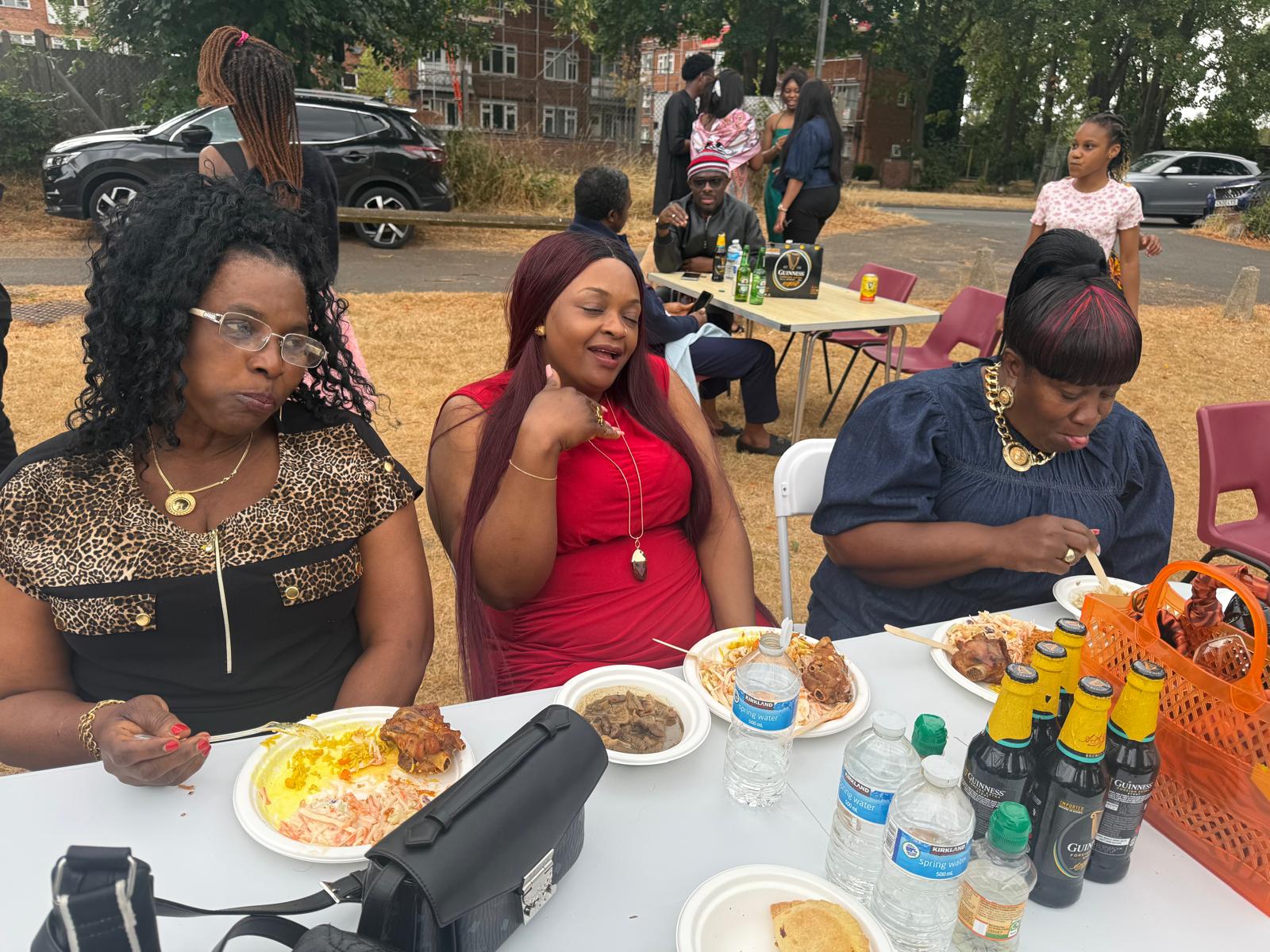 Women of the community enjoying Nigerian dishes at the AUF outdoor gathering