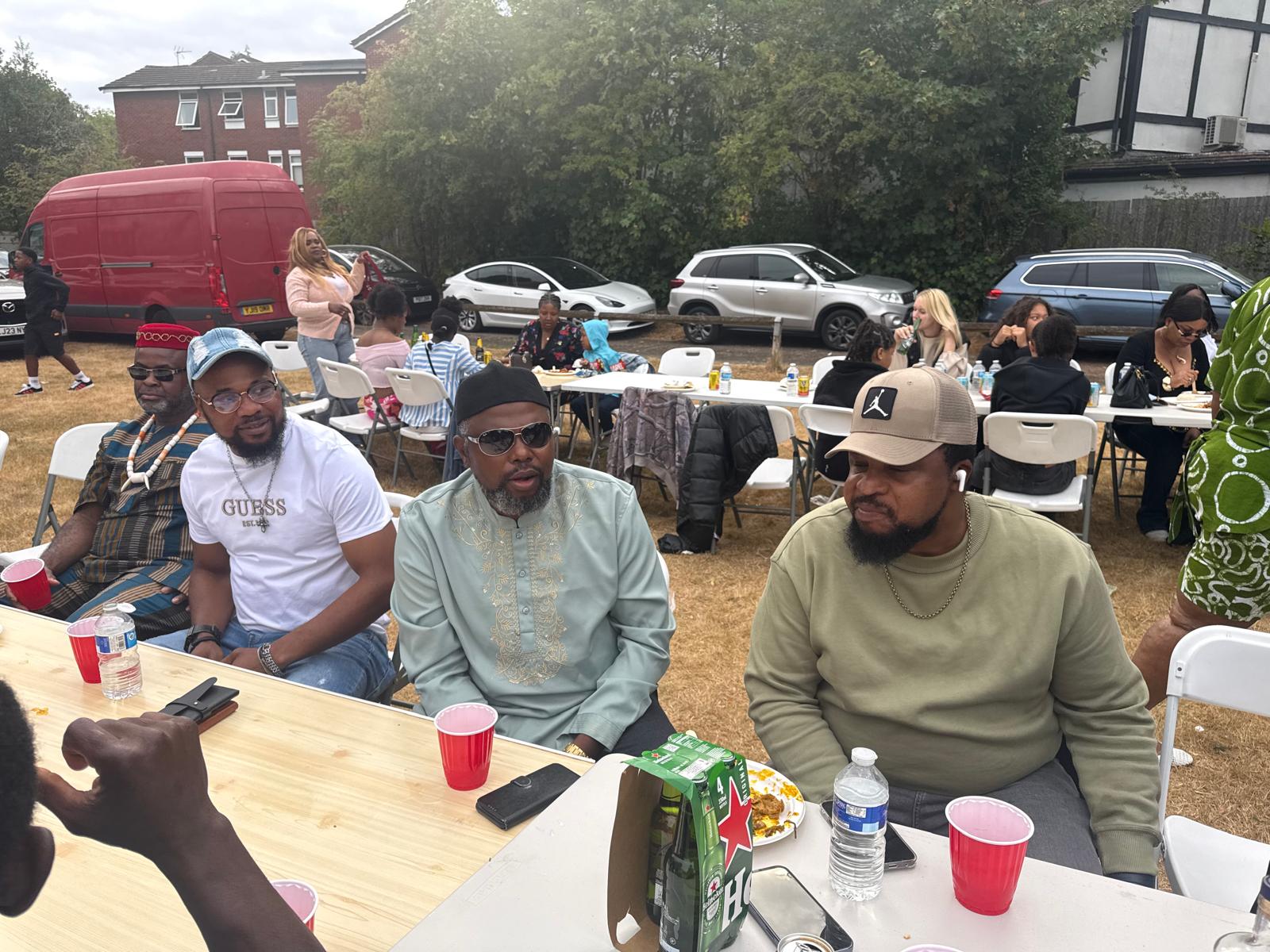 Members seated in traditional attire at an AUF outdoor event